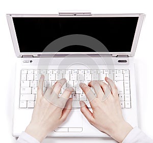 Human hands over laptop keypad during typing.