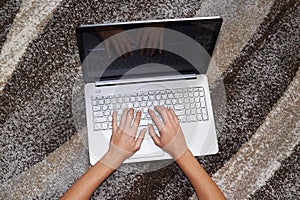 Human hands over laptop keypad during typing