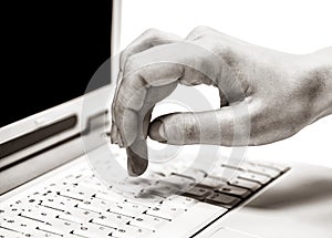 Human hands over laptop keypad during typing.