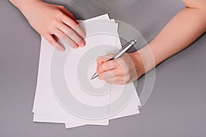 Human hands with pencil writing on paper and erase rubber on wooden table background