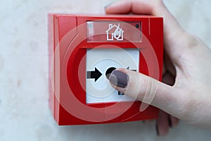 Human hands are pulling red fire alarms on the white walls along the mall corridor.The concept of a picture dical use of non-psych