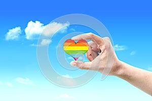 Human hands showing heart with rainbow flag