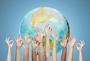 Human hands showing ok sign over earth globe