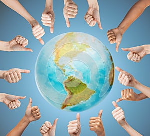 Human hands showing thumbs up in circle over earth