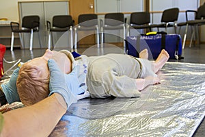 Human hands stabilisations the neck from a medical training puppet