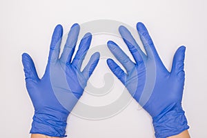 Human hands wearing blue surgical latex nitrile gloves for doctor and nurse protection during patient examination on white