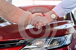 Human handshakes close up on car background