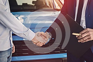 Human handshakes close up on car background