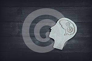 Human head and face with gear sign  on wood table background. Brain of thinking about driving the organization , Symbol of Process