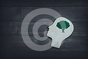 Human head and face with green tree sign on wood table background. Brain of thinking about green nature , Symbol of Process and