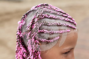 Human head with pink dreadlocks hairstyle, young Caucasian girl, close-up view