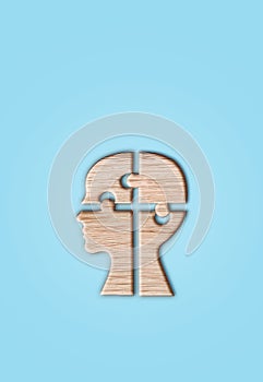 Human head silhouette with a jigsaw piece cut out on the blue background, mental health concept