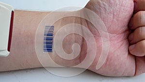 Human with implant micro chip scanning barcode imprinted on his hand