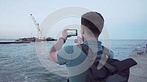 Human journalist make report on sunken tanker Delfi in Odessa. Male blogger shoots video on phone, publish post about