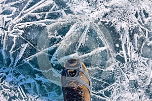 Human legs in hiking boot in ice crampons on the texture Baikal