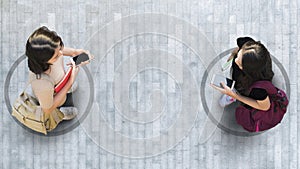 Human life in Social distance. Aerial top view with two student women with smartphone stand at grey pavement street road with