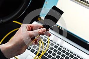 Human making car diagnostics using OBD device and computer.