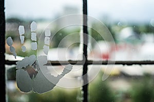 Human palm trace on window background. Man hand shape sign on window glass