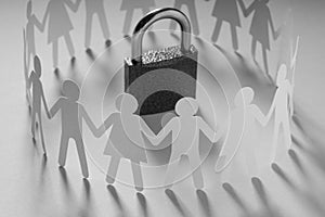 Human paper figures standing around padlock on a white surface. Freedom, human rights, independence.