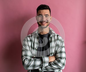 A human in plaid, arms crossed, smiling with mouth slightly open