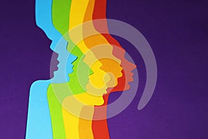 The human rainbow colored profiles are cut out of paper on a purple background