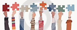 Human resources concept. Raised arms and hand up of multicultural business people holding a jigsaw puzzle piece. Job occupation