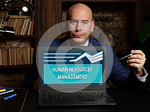 HUMAN RESOURCES MANAGEMENT text in search bar. Bookkeeping clerk looking for something at laptop. HUMAN RESOURCES MANAGEMENT