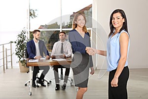 Human resources manager shaking hands with applicant during job interview