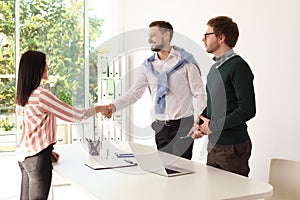 Human resources manager shaking hands with applicant during job interview