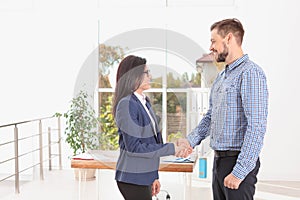 Human resources manager shaking hands with applicant during job interview