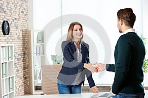 Human resources manager shaking hands with applicant before job interview