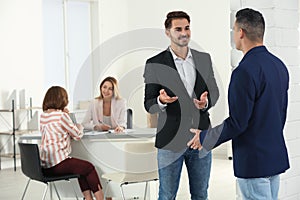 Human resources manager speaking with applicant before job interview