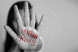 Human rights concept. woman raised her hand for dissuade, hand write the word human rights in red color photo