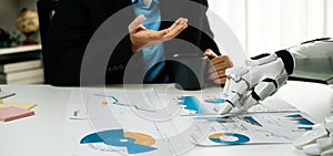 Human and Robot Collaboration in Business Analysis with Charts, Data Reports, and Coffee on Office Table Reflecting