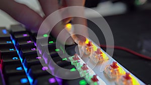 A human's hand assembles the keys of a mechanical keyboard with red switches, close-up shots and in motion