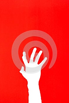 human`s hand reaching out for help on red background