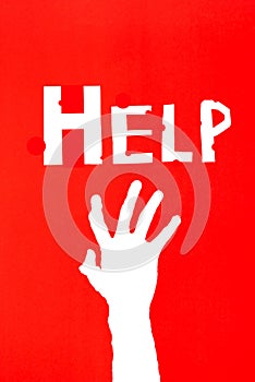 Human`s hand reaching out for help on red background with letter