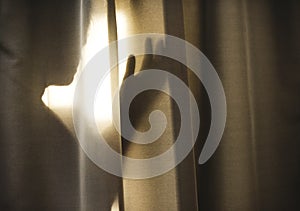 Human shadow behind a curtain