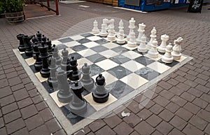 Human sized chest board in public square with white and black set of pieces