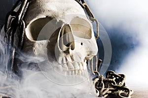 Human skull with chain and smoke