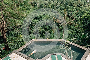 Human swimming in Bali infinity pool