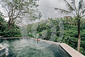 Human swimming in Bali infinity pool