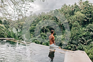 Human swimming in Bali infinity pool