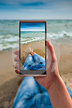 Human take a selfie of legs on a sea beach