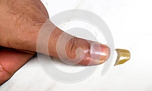 Human thumb and clipped nail on white background