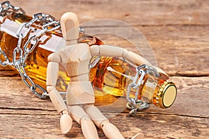 Human wooden dummy sitting with bottle.