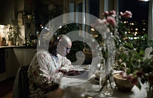 Humanoid robot programming on laptop in modern apartment at night