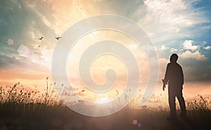 Humble man standing on sunlight with meadow autumn sunset