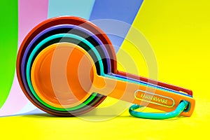 Farberware plastic measuring cups on a colorful background.