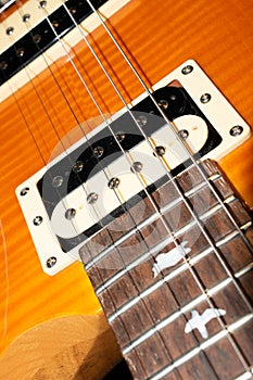 Humbucker pickup on a PRS SE Santana electric guitar in yellow product shot